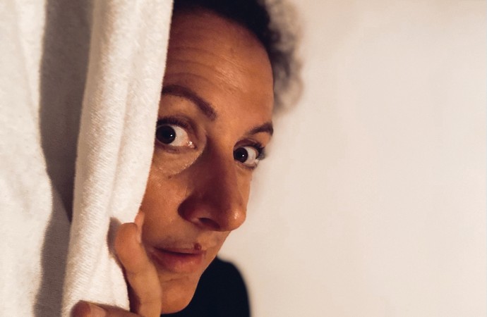 Eine Frau guckt hinter einem Vorhang hervor. Eine Frau guckt hinter einem Vorhang hervor.