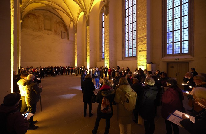Gruppe von Menschen mit Lichtern in den Händen, singt in der Dalheimer Klosterkirche.