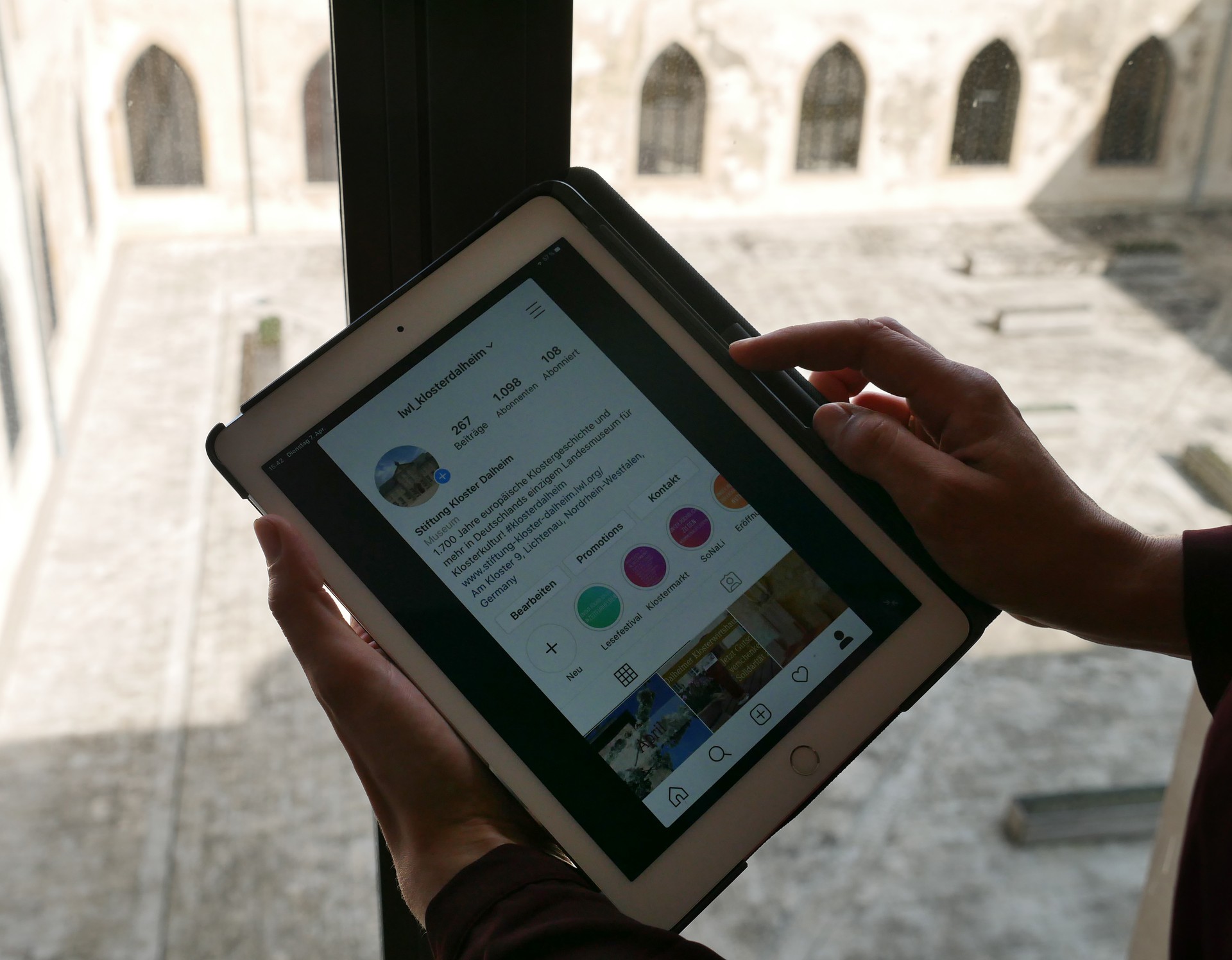 Jemand hält ein Tablet, auf dem Instagram geöffnet ist.