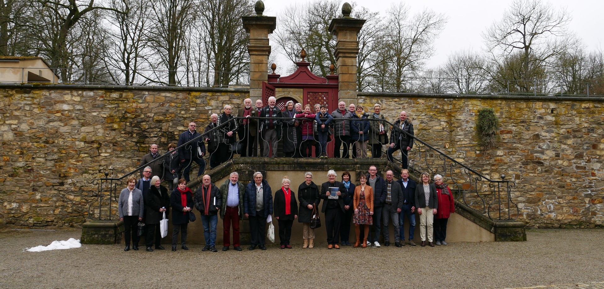Rund dreißig Mitglieder vom Verein der Freunde stehen im Ehrenhof und schauen lächelnd in die Kamera.
