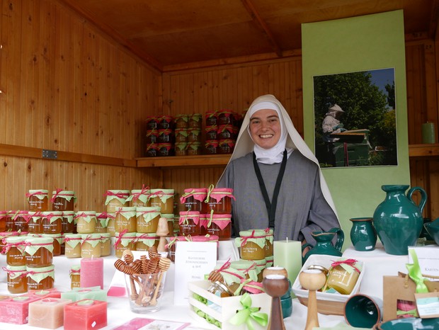 Auf dem Foto sieht man eine Schwester von Maria Stella Matutina, die ihre Waren in einer Klostermarkthütte präsentiert. Auf dem Foto sieht man eine Schwester von Maria Stella Matutina, die ihre Waren in einer Klostermarkthütte präsentiert.