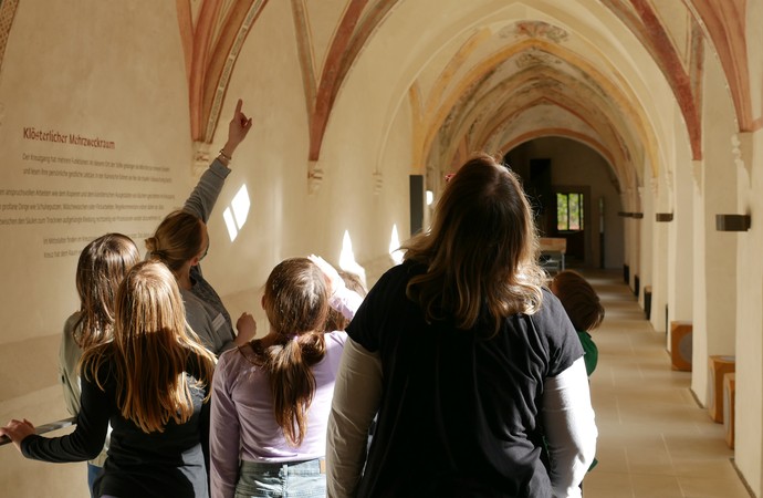 Besucher schauen sich die Deckenmalereien im Kreuzgang an.