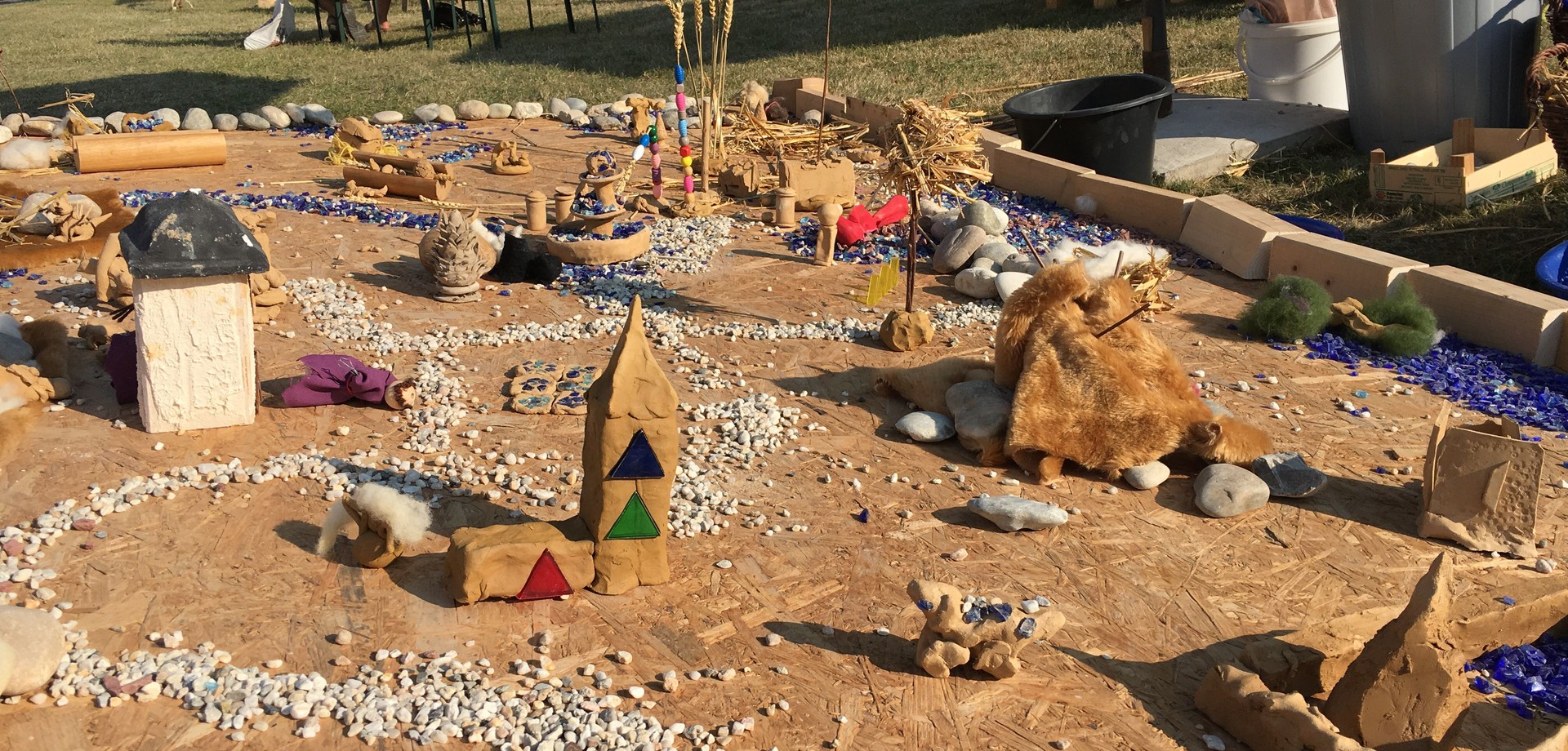 Auf einer Holzplatte haben Kinder mit unterschiedlichen Materialien ein Kloster nachgestellt.