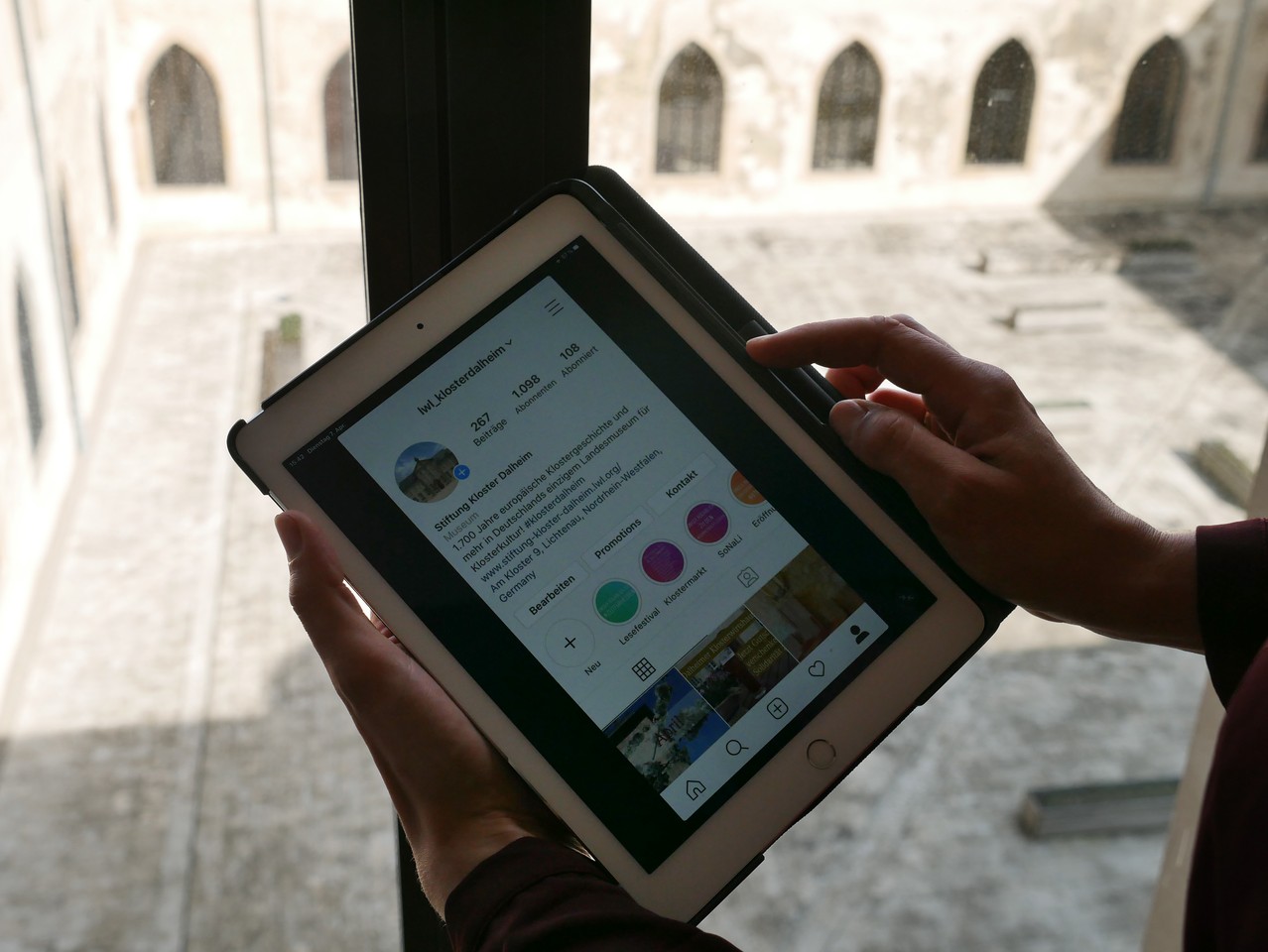 Jemand hält ein Tablet, auf dem Instagram geöffnet ist.