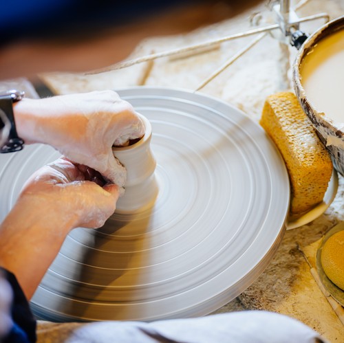 Zwei Hände töpfern ein Gefäß.
