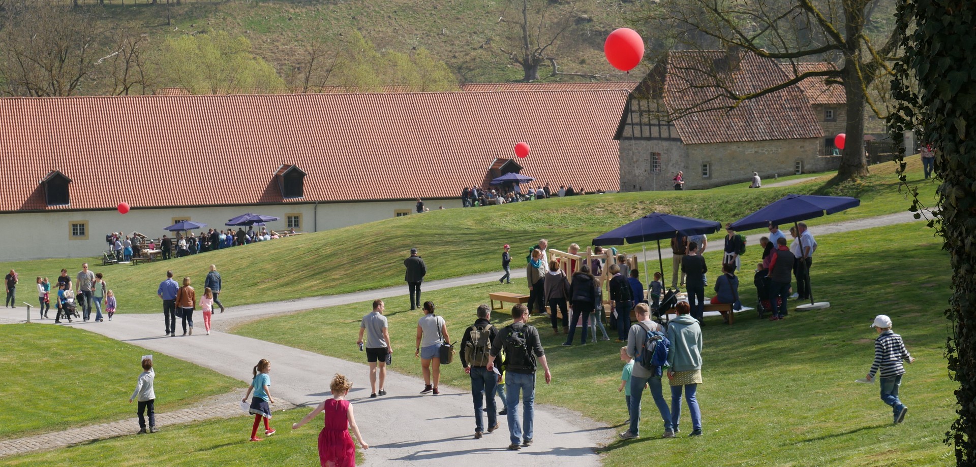 Blick auf das Klostergelände. Kinder und Erwachsene laufen darauf herum.