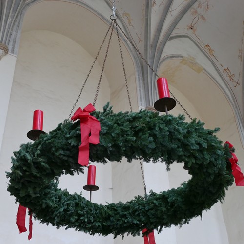 In einer Kirche hängt ein Adventskranz.