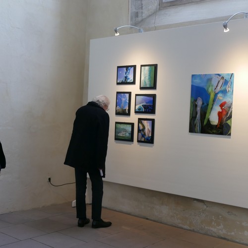 Ein Mann betrachtet die Werke von Max Heide in der Ausstellung.