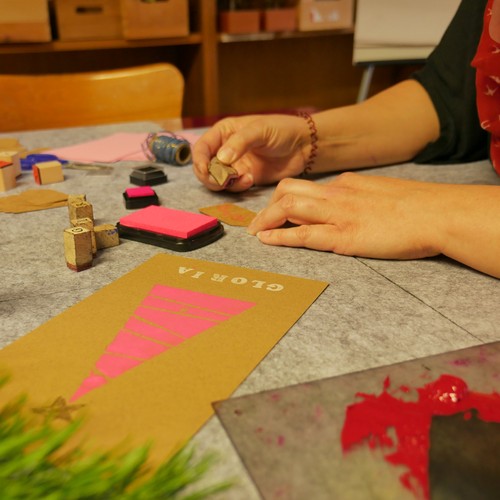 Eine Frau arbeitet mit Stempeln an Weihnachtskarten.