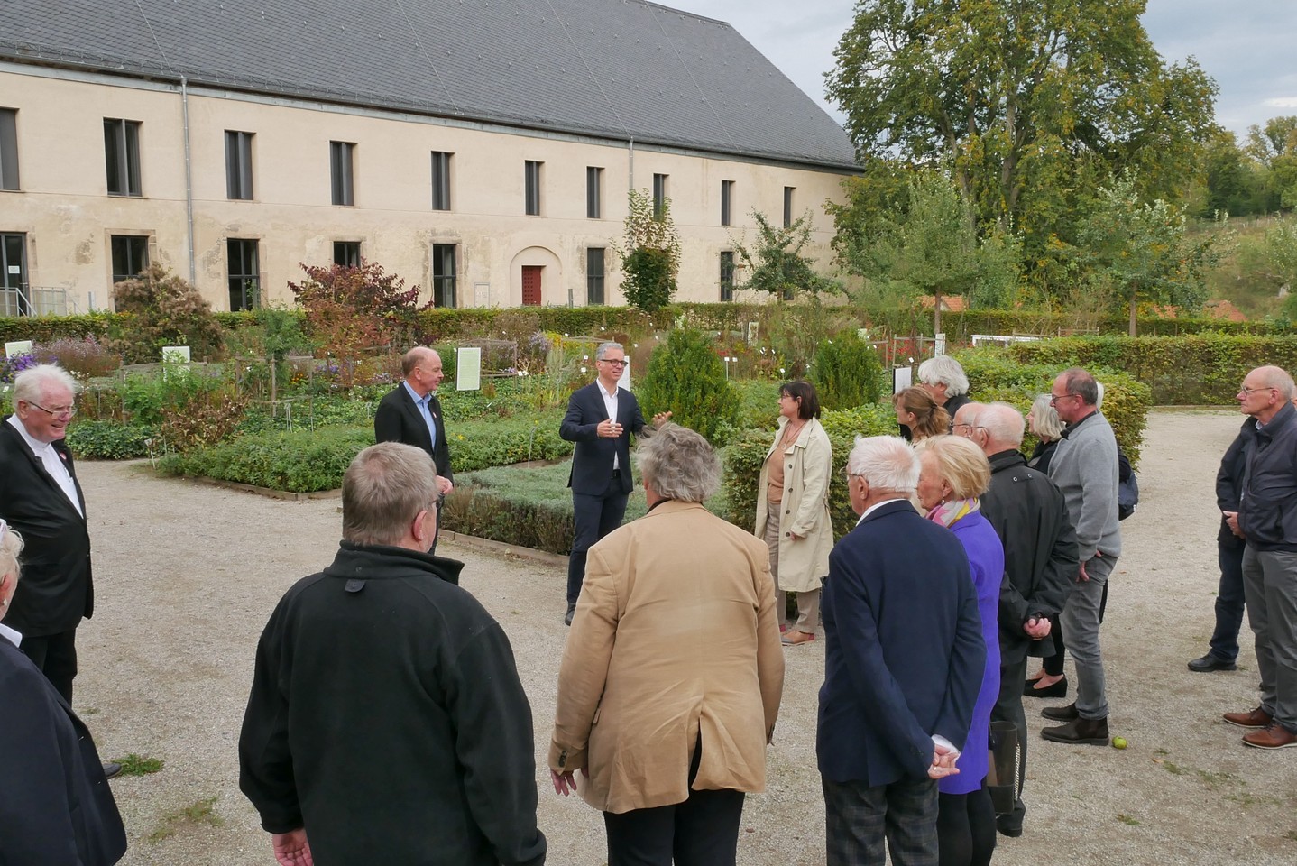 Mehrere Mitglieder vom Verein der Freunde nehmen an einer Führung im Garten mit Museumsdirektor Dr. Ingo Grabowsky teil.