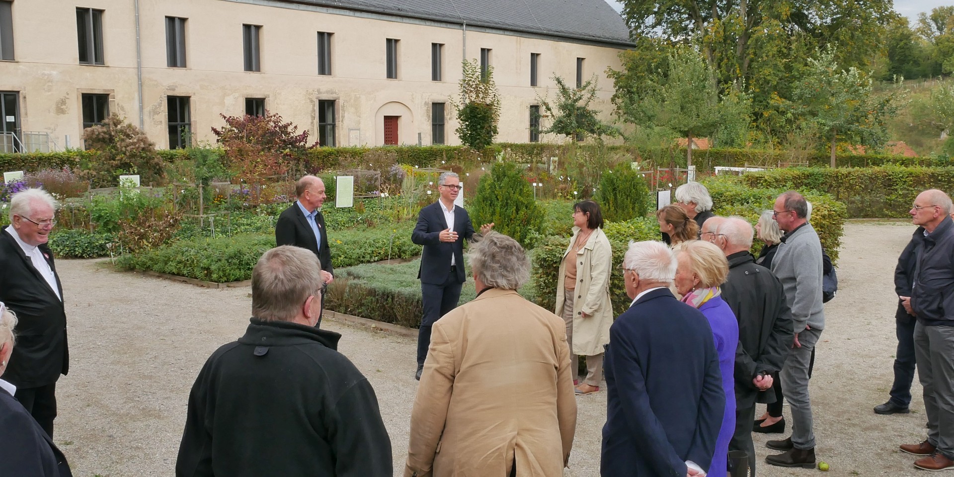 Mehrere Mitglieder vom Verein der Freunde nehmen an einer Führung im Garten mit Museumsdirektor Dr. Ingo Grabowsky teil.